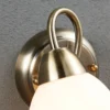 Aplique de pared Lindby Mael, altura 20 cm, latón envejecido, interruptor