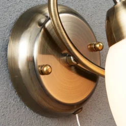 Aplique de pared Lindby Mael, altura 20 cm, latón envejecido, interruptor