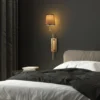 Aplique de pared Lumora, marrón/dorado, altura 72 cm, tejido/metal, E27