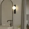 Aplique para baño Lindby Tavrik, negro/blanco, altura 30 cm, cristal