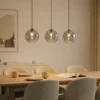 Lámpara colgante Lucande Brillar, gris humo, cristal, 3 luces, 128 cm