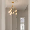 Lámpara de araña LED Nuura Asteea 9, Ø 66 cm, color latón/transparente