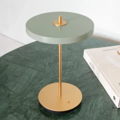 Lámpara de mesa LED recargable UMAGE Asteria Move, verde oliva/latón, 31 cm